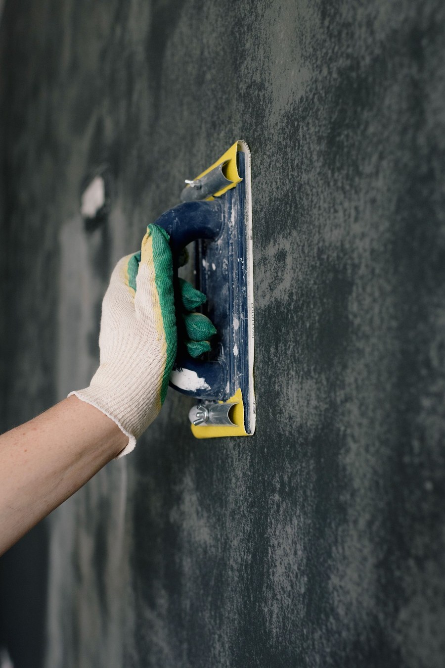 A float working wet render across a dark textured wall