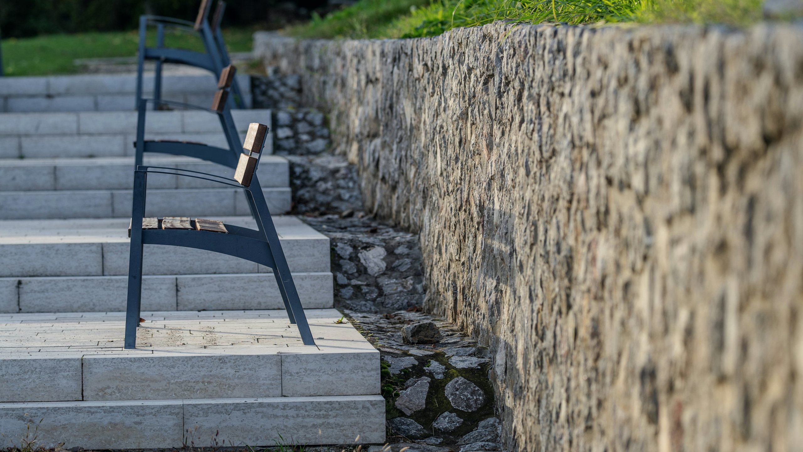 A stone retaining wall terraced into a bank with steps